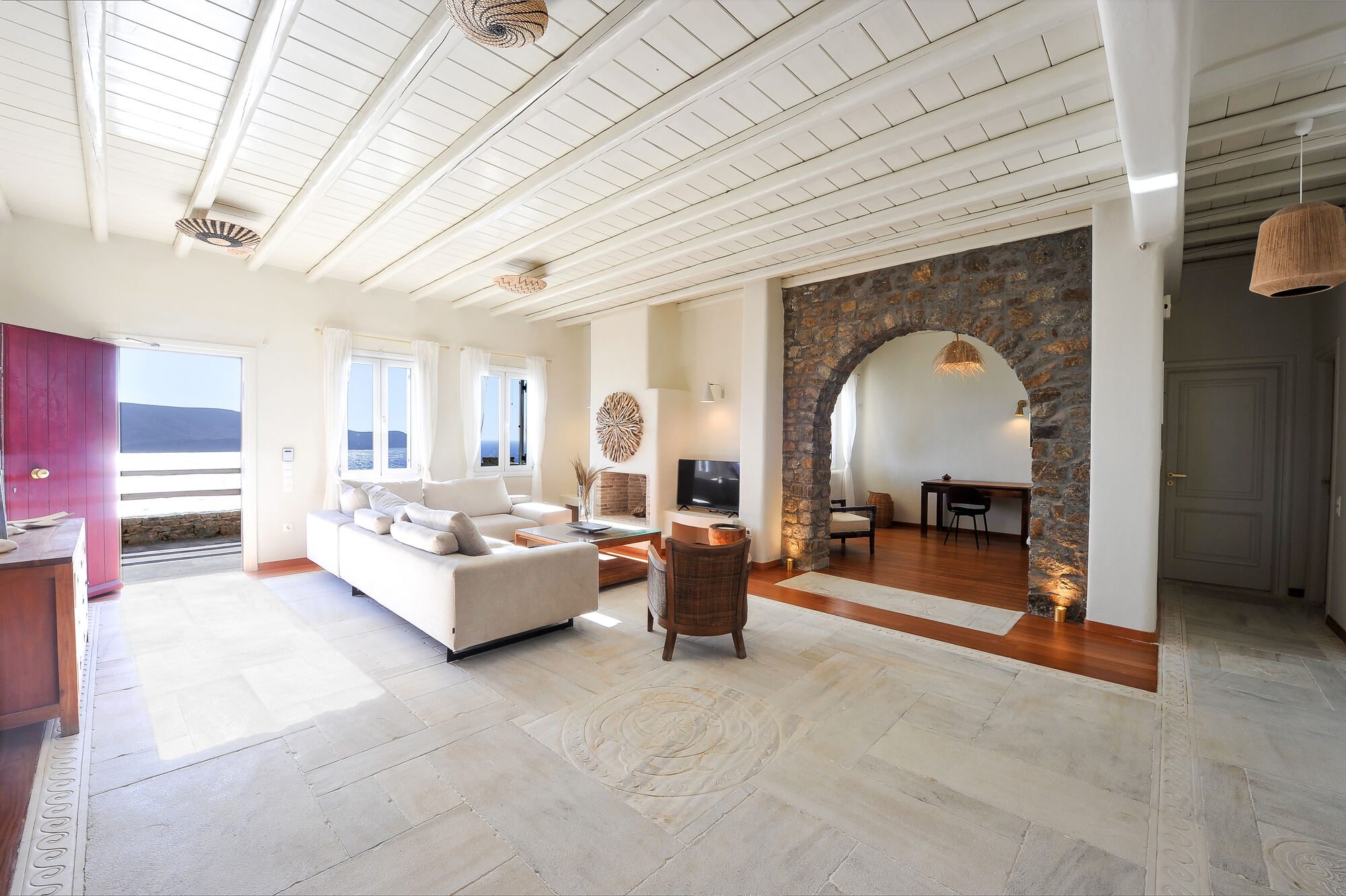 The main lounge with its stone arch, fireplace and a view of the sea